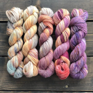 Пять пасм пряжи Alpaca Linen в ярких цветах - кремово-оранжевом, персиковом, коралловом, фиолетово-розовом и темно-фиолетовом с красивым меланжем